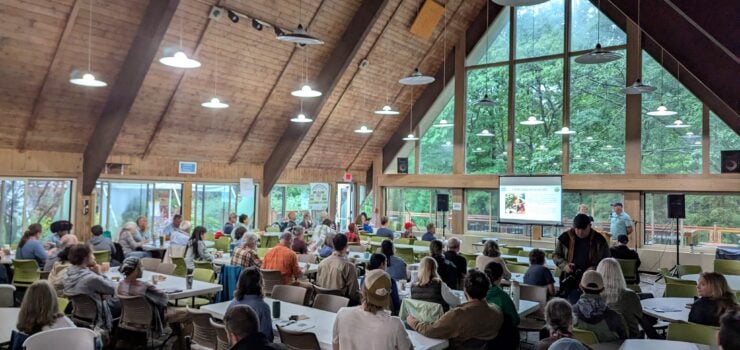 People seated around round tables in large room at the 2025 Northern Michigan Small Farm Conference.