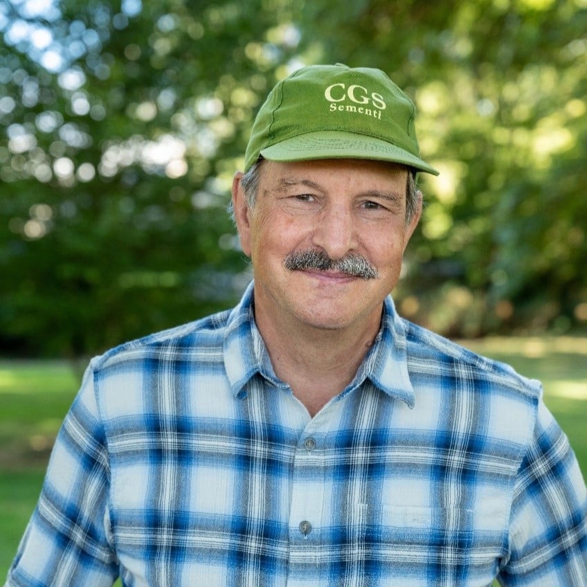 portrait of Jim Myers, wearing a green hat and blue plaid shirt